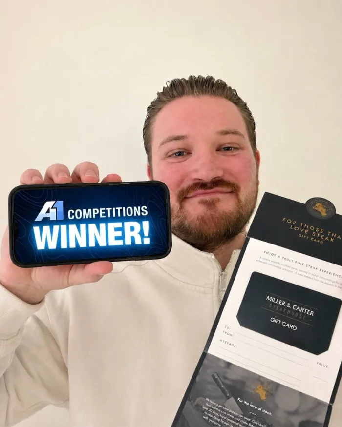 A1 Competitions winner holding a WINNER sign