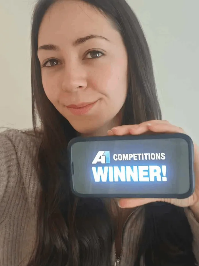 A1 Competitions winner holding a WINNER sign