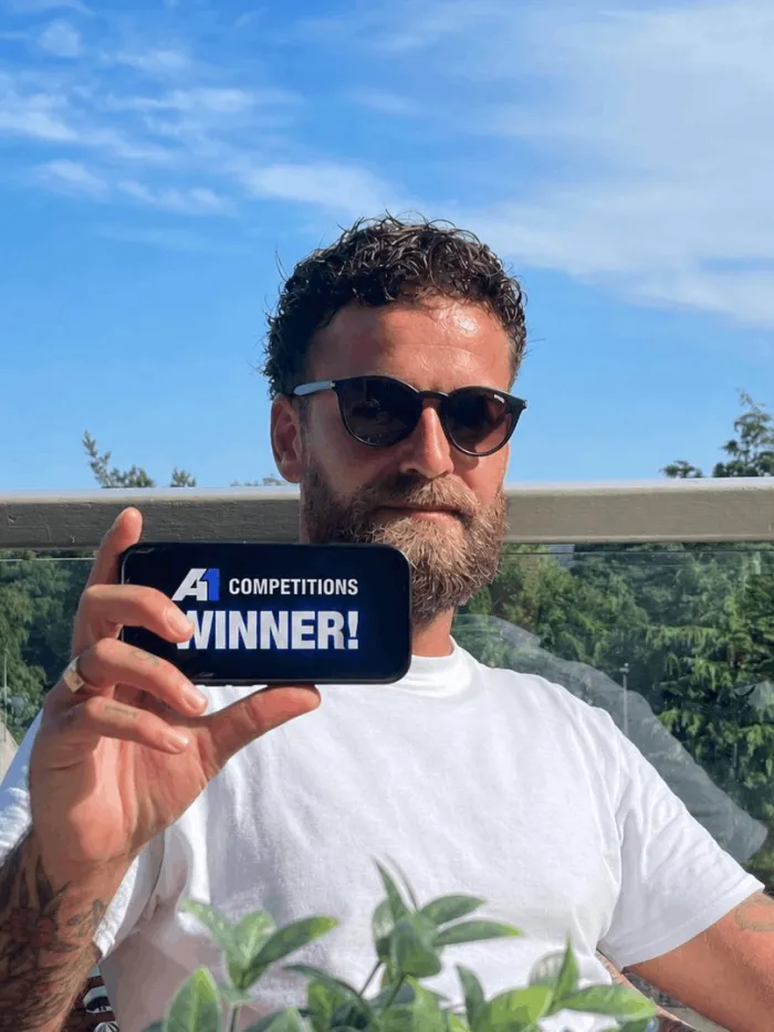 A1 Competitions winner holding a WINNER sign