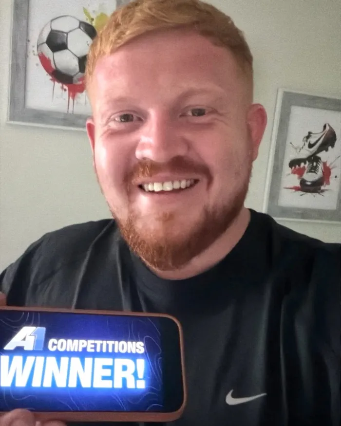 A1 Competitions winner holding a WINNER sign